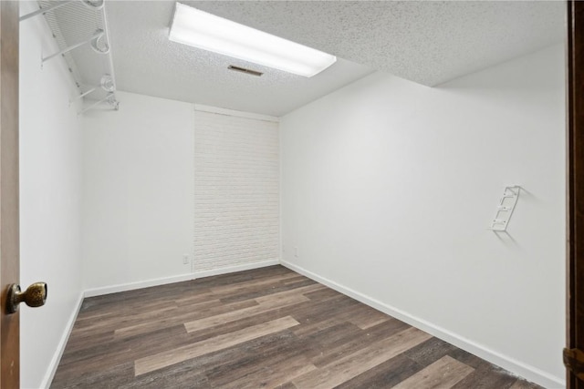 interior space featuring baseboards, dark wood-style flooring, and a textured ceiling