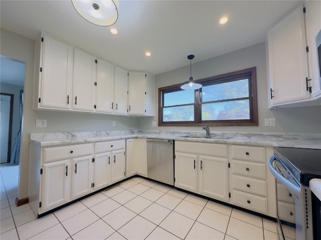 kitchen with appliances with stainless steel finishes, a sink, light tile patterned floors, light stone counters, and white cabinetry