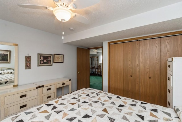 carpeted bedroom with a closet, a textured ceiling, and ceiling fan