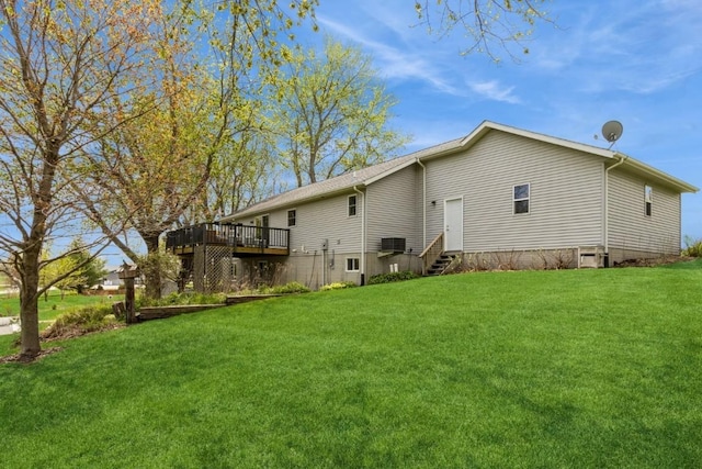 rear view of property featuring a yard, a deck, and entry steps