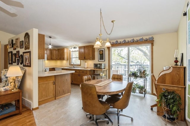 dining area featuring baseboards, light wood-style flooring, and a toaster