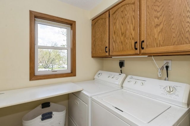 washroom featuring washing machine and dryer and cabinet space