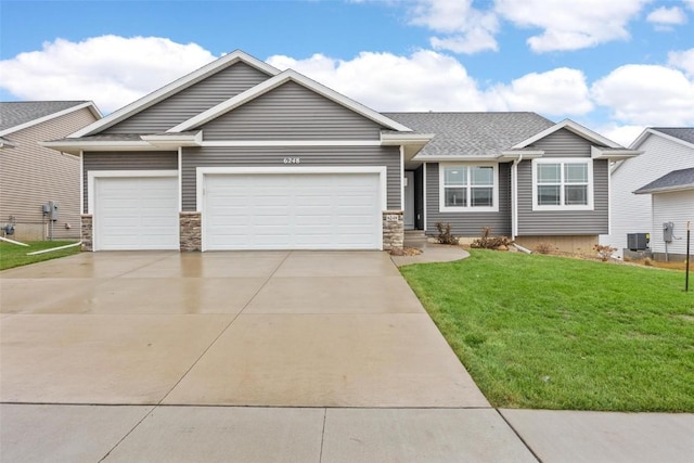 view of front facade with driveway, a front lawn, an attached garage, a shingled roof, and stone siding