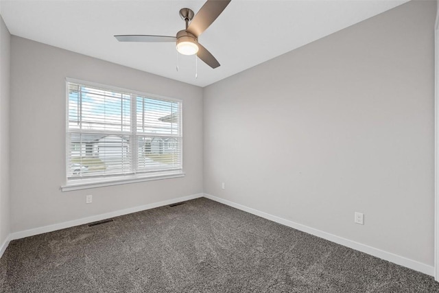 empty room featuring baseboards, visible vents, and dark colored carpet