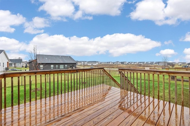wooden deck featuring a yard and a residential view