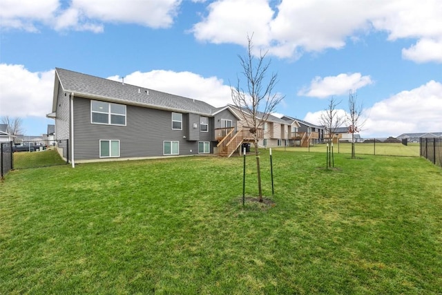 rear view of house with a fenced backyard, stairs, a yard, and a wooden deck
