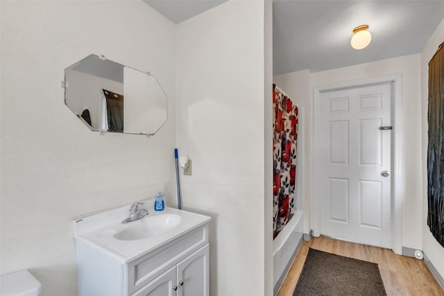 full bathroom with vanity, wood finished floors, and shower / bath combination with curtain