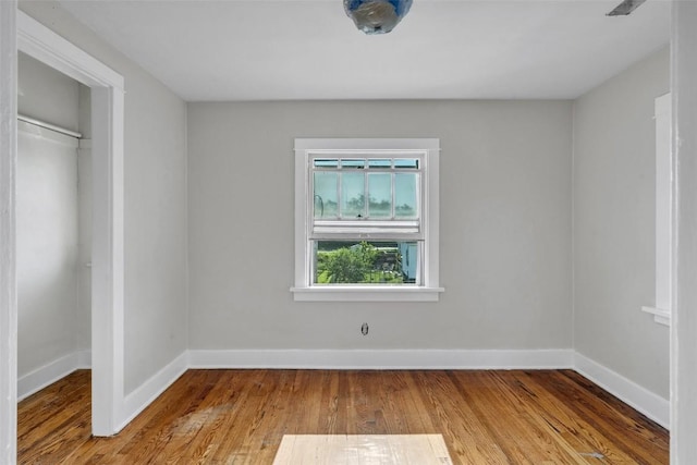 unfurnished bedroom with a closet, baseboards, and wood finished floors