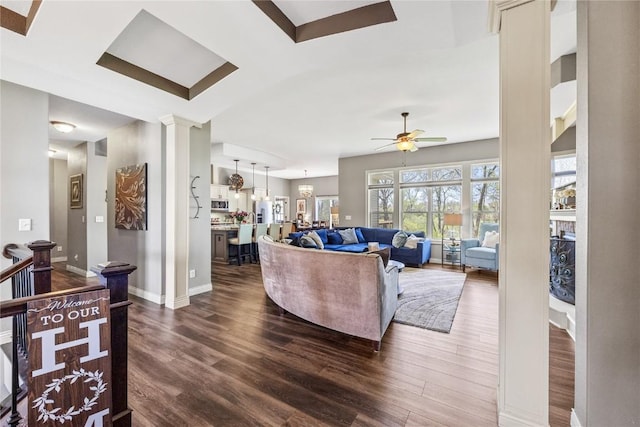 208 Willowood Dr, Hiawatha, IA 52233 - living area with dark wood-style floors, ornate columns, ceiling fan, and baseboards