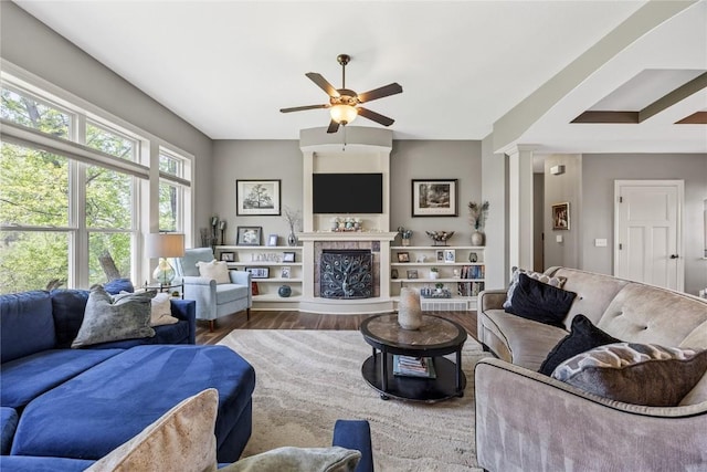 208 Willowood Dr, Hiawatha, IA 52233 - living area featuring a ceiling fan, wood finished floors, decorative columns, and a fireplace with raised hearth