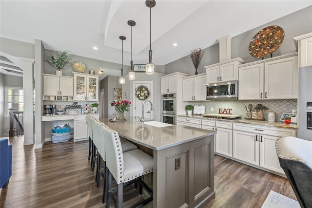 208 Willowood Dr, Hiawatha, IA 52233 - kitchen with appliances with stainless steel finishes, a sink, backsplash, dark wood-type flooring, and a breakfast bar area