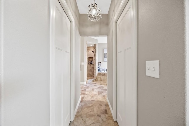 208 Willowood Dr, Hiawatha, IA 52233 - hall with a chandelier, stone finish flooring, and baseboards