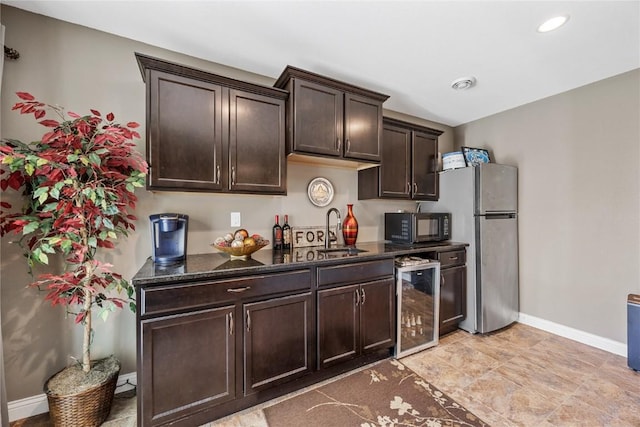 208 Willowood Dr, Hiawatha, IA 52233 - kitchen with wine cooler, black microwave, freestanding refrigerator, baseboards, and dark brown cabinetry