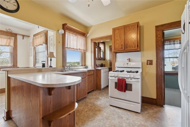 527 Swisher View Dr SW, Swisher, IA 52338 - kitchen with white appliances, a peninsula, brown cabinetry, light countertops, and a ceiling fan