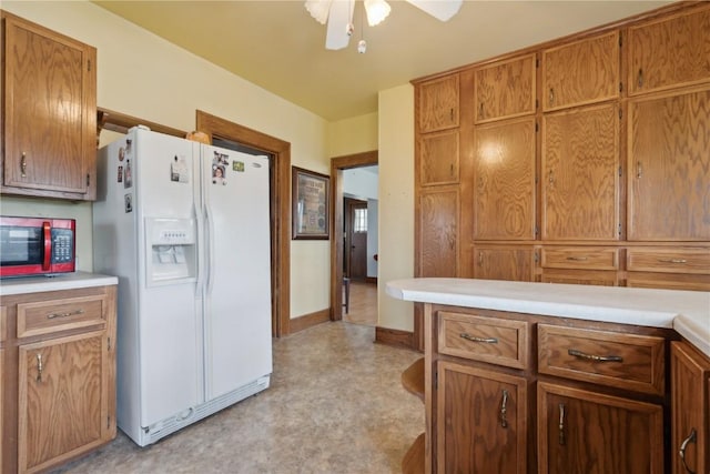 kitchen with light countertops, light floors, white fridge with ice dispenser, and ceiling fan