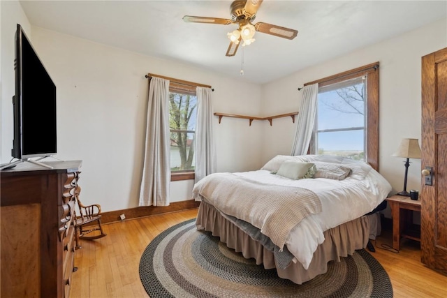 bedroom with a ceiling fan and light wood-type flooring