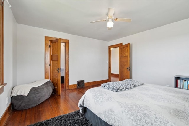 bedroom with a ceiling fan, baseboards, and wood finished floors