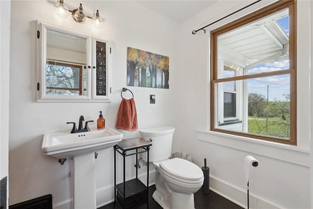 bathroom featuring baseboards and toilet