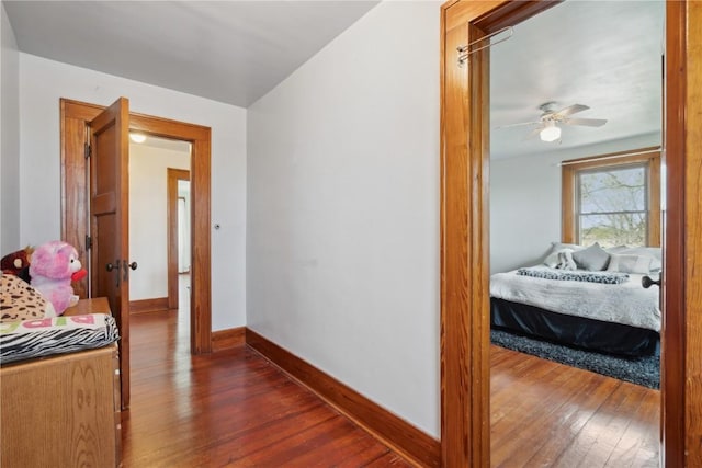 bedroom with baseboards and dark wood-type flooring