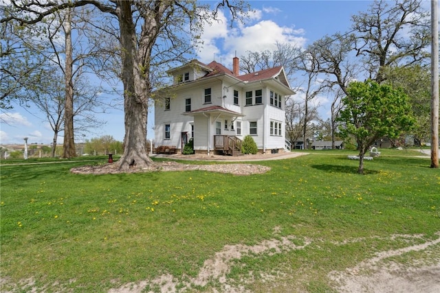 view of front facade with a chimney and a front yard