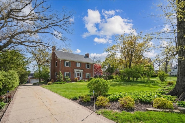 colonial inspired home with a chimney and a front yard