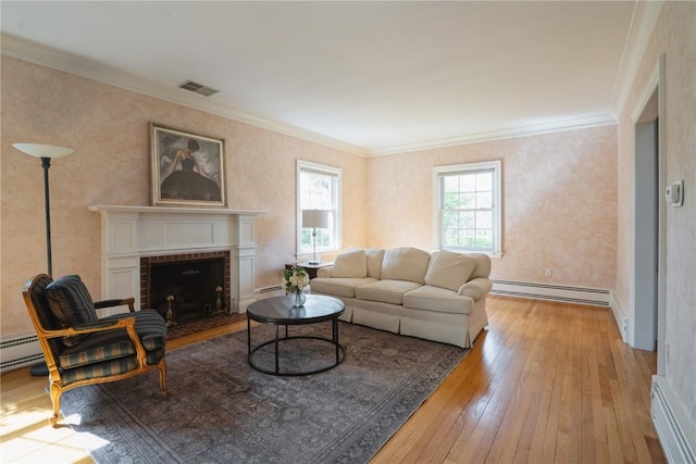 living room featuring visible vents, a fireplace, baseboard heating, ornamental molding, and hardwood / wood-style floors