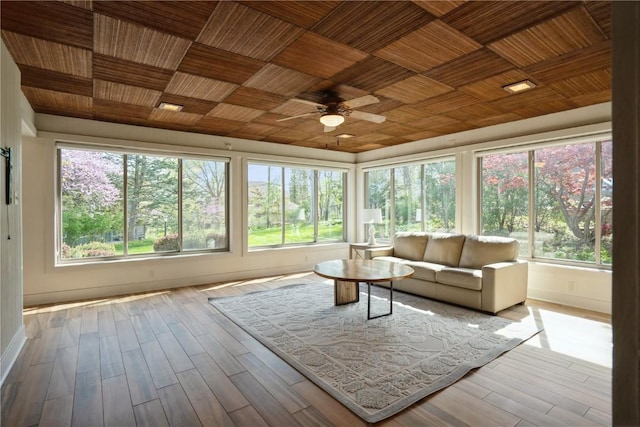 sunroom / solarium with a healthy amount of sunlight, baseboards, and wood finished floors