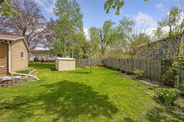 view of yard featuring a fenced backyard, a storage unit, and an outbuilding