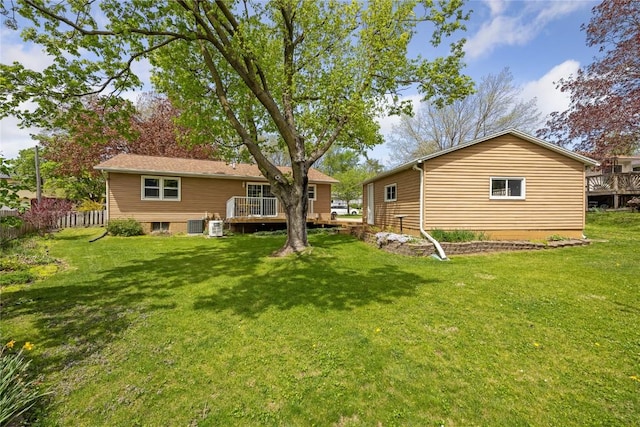 back of property featuring fence, a yard, and a deck