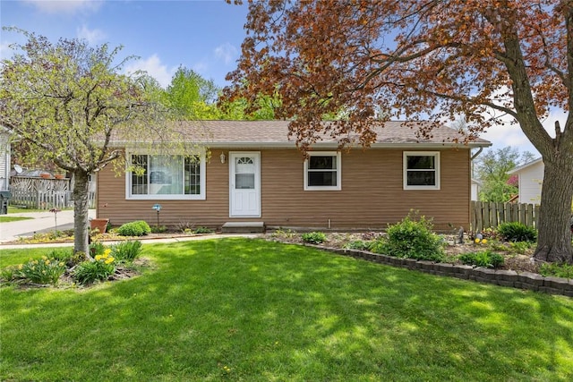 ranch-style house featuring fence, entry steps, and a front lawn