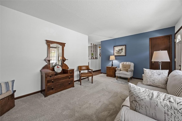 living area with a textured ceiling, baseboards, and light colored carpet