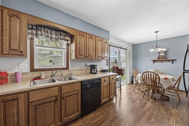 kitchen featuring a sink, light countertops, a textured ceiling, black dishwasher, and dark wood-style floors
