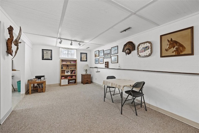carpeted dining area featuring track lighting and baseboards