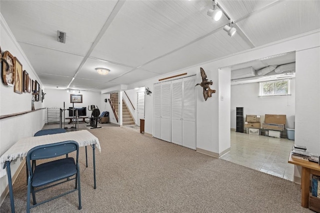 interior space featuring rail lighting, carpet, and stairway
