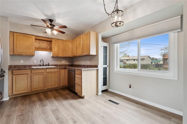 kitchen with stainless steel dishwasher, visible vents, dark countertops, a sink, and light wood finished floors