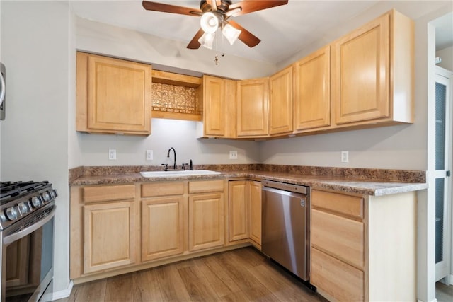 kitchen featuring a ceiling fan, wood finished floors, light brown cabinetry, a sink, and stainless steel appliances