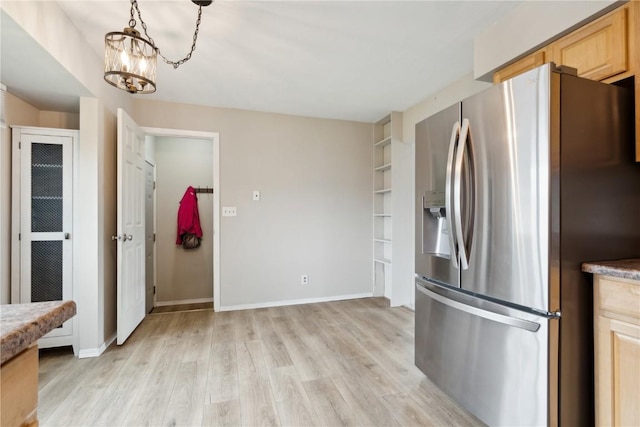 kitchen featuring light brown cabinets, baseboards, stainless steel refrigerator with ice dispenser, a chandelier, and light wood-style flooring