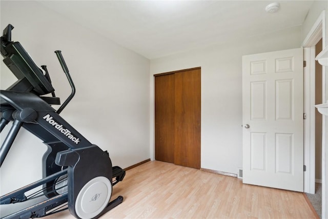 workout area featuring baseboards and wood finished floors