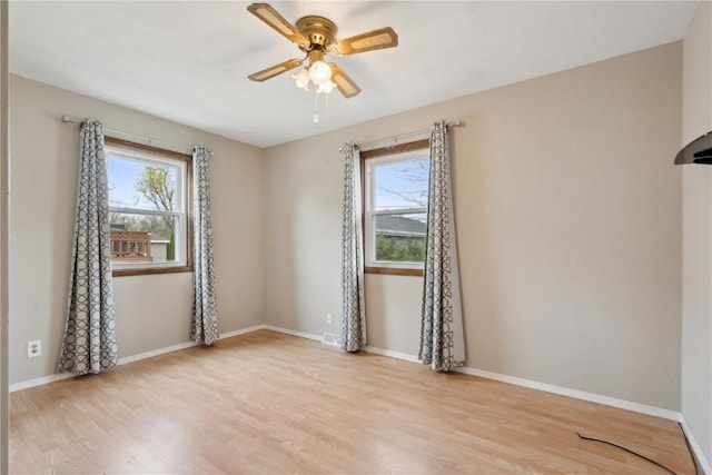 spare room featuring baseboards, ceiling fan, and wood finished floors