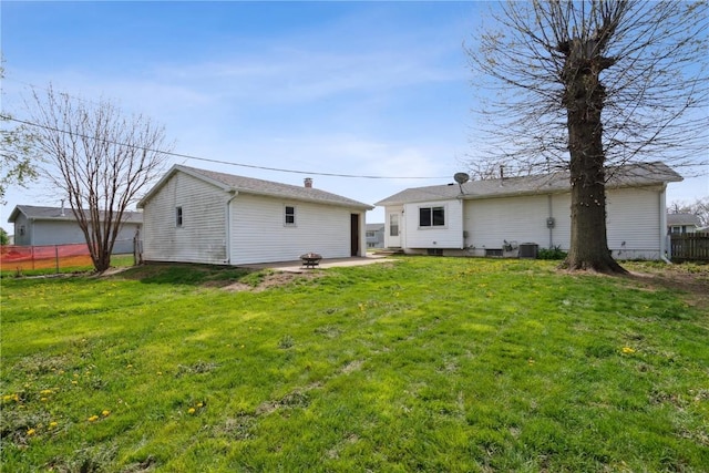 rear view of property featuring a patio, central AC unit, fence, and a yard