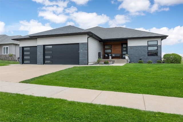 prairie-style home featuring a porch, a front yard, a garage, concrete driveway, and stone siding