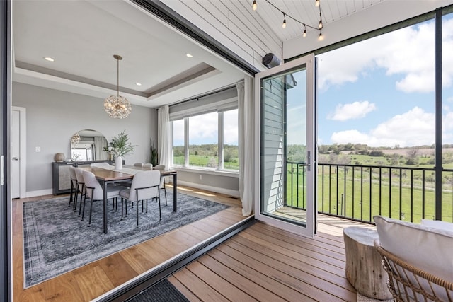 dining area with baseboards, arched walkways, wood finished floors, and a notable chandelier