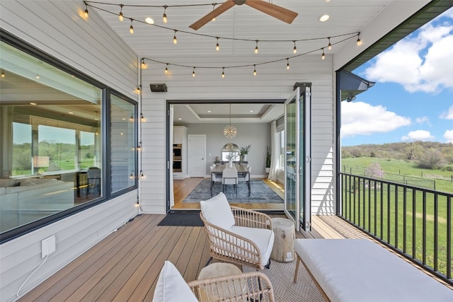 wooden terrace with a yard, fence, and a ceiling fan