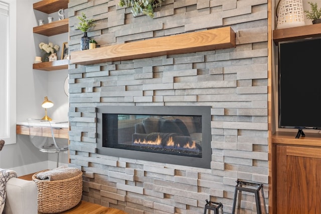 details featuring a glass covered fireplace and wood finished floors