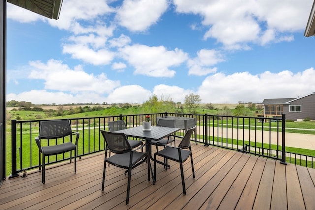 wooden deck featuring outdoor dining space and a rural view