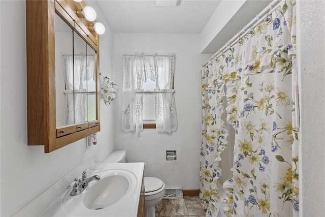 bathroom featuring vanity, a shower with shower curtain, toilet, and visible vents