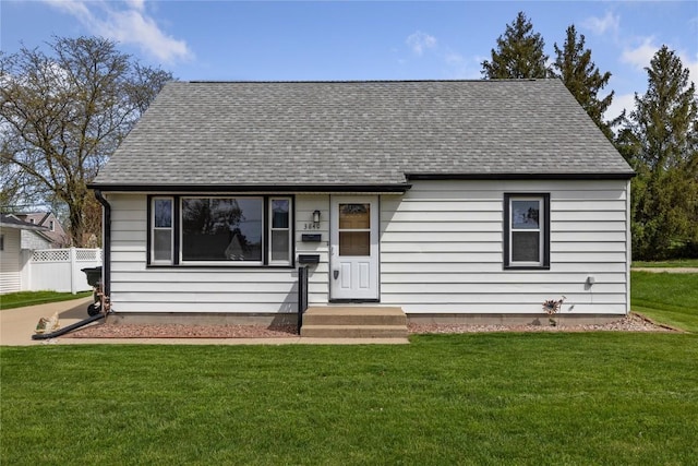 view of front of home featuring a shingled roof and a front yard