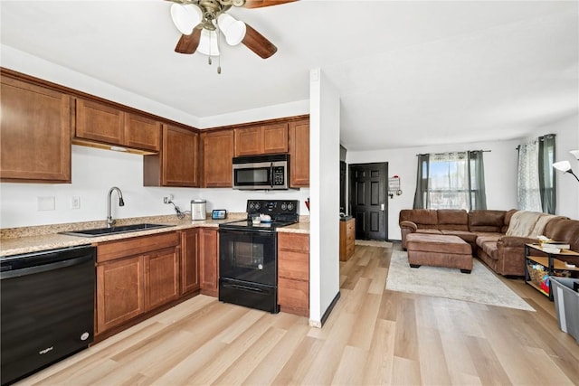 kitchen featuring ceiling fan, light wood-type flooring, a sink, black appliances, and open floor plan