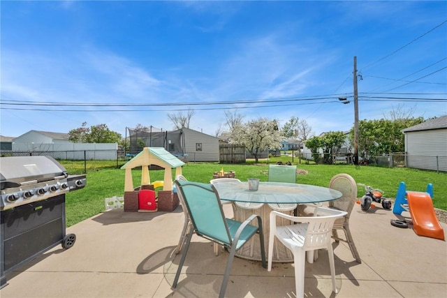 view of patio with a fenced backyard, outdoor dining space, and a trampoline