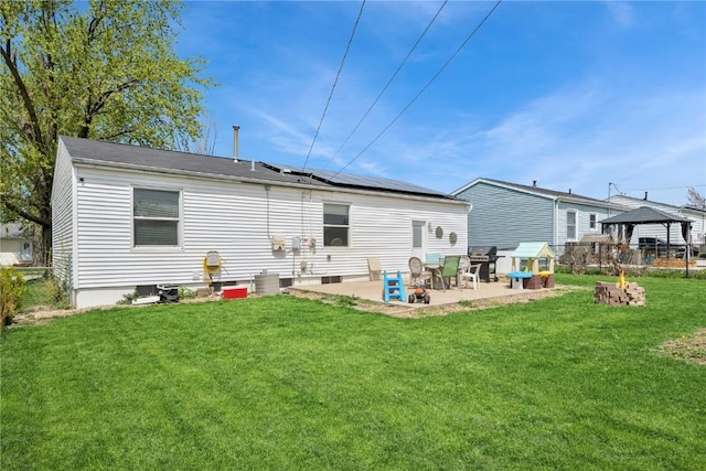 back of property with a yard, a patio, a gazebo, and roof mounted solar panels